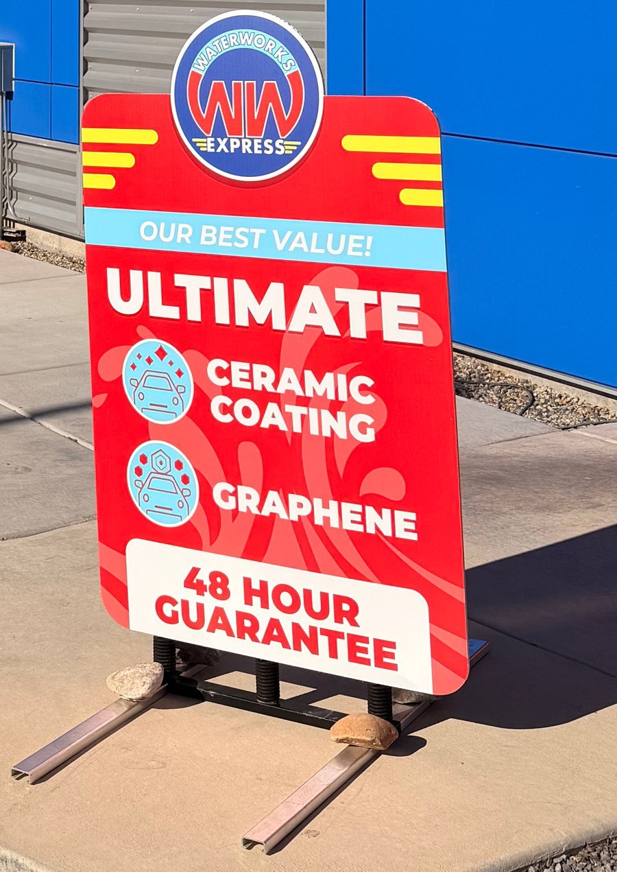 Forecourt sign at WaterWorks Express reading Our Best Value, Ultimate, with ceramic coating, graphene and a 48 hour guarantee.